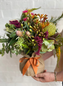 Native blooms in hessian covered vase